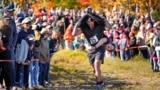 Nic Vinsonhaler carries Tara Rogowski while competing in the North American Wife Carrying Championship, Oct. 12, 2024, at Sunday River ski resort in Newry, Maine. 