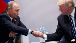 Presiden AS Donald Trump (kanan) dalam pertemuan dengan Presiden Rusia Vladimir Putin di sela KTT G20 di Hamburg, Jerman 7 Juli 2017 (foto: dok). 