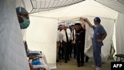 French Prime Minister Francois Bayrou (center in a tie) and other officials visit a hospital in Mamoudzou on Mayotte, on Dec. 30, 2024. 