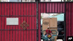 Un hombre transporte productos en Beijing el 15 de agosto del 2022. Foto AP.