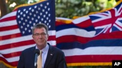 With the U.S. and Hawaii flags fluttering in the background, Defense Secretary Ash Carter speaks at a press conference during a defense ministers meeting of ASEAN, in Kapolei, Hawaii, Sept. 30, 2016.