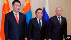 From right: Russian President Vladimir Putin, Mongolian President Tsakhiagiin Elbegdorj and Chinese President Xi Jinping pose during their meeting at the sidelines of the Shanghai Cooperation Organization summit in Dushanbe, Tajikistan, Sept. 11, 2014. 