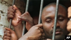 A Hutu man looks out the window of his cell at a Kigali prison Wednesday, April 5, 1995. 