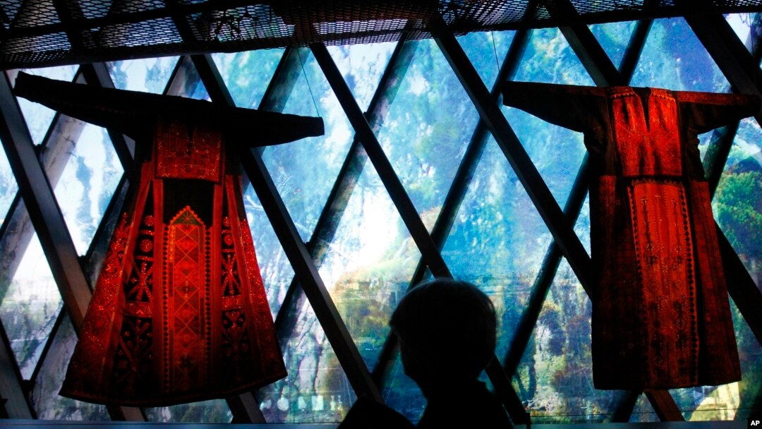 Seorang perempuan memperhatikan pakaian tradisional Palestina, thobe, dalam sebuah pameran di Museum Quai Branly di Paris, Perancis, 7 Februari 2011.