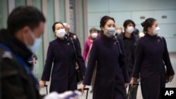 Flight crew members wearing face masks walk through the international arrivals area at Beijing Capital International Airport in Beijing, Thursday, Jan. 30, 2020. China counted 170 deaths from a new virus Thursday and more countries reported…