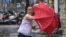 In this photo released by Xinhua News Agency, a man holding an umbrella struggles against the wind following the landfall of typhoon Yagi in Haikou, south China's Hainan Province, Sept. 6, 2024. 