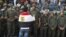 An anti-Mursi protester with an Egyptian flag around his shoulders talks to soldiers standing guard outside the Egyptian presidential palace in Cairo December 9, 2012.