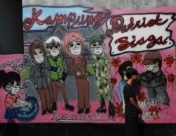 Mural "kesadaran virus corona " di desa Rawa Pasung, Bekasi di pinggiran Jakarta, Indonesia, Kamis, 23 Juli 2020. (AP Photo / Achmad Ibrahim) Format: JPG