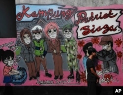 Mural "kesadaran virus corona " di desa Rawa Pasung, Bekasi di pinggiran Jakarta, Indonesia, Kamis, 23 Juli 2020. (AP Photo / Achmad Ibrahim) Format: JPG