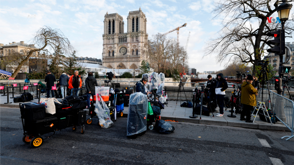 Periodistas se encuentran frente a la catedral de Notre-Dame de París, antes de su ceremonia oficial de reapertura.