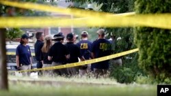 FILE - Investigators confer before looking for evidence around the baseball field in Alexandria, Virginia, June 14, 2017, that was the scene of a shooting involving Republican Congressman Steve Scalise and others.