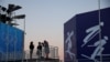 FILE - Members of the media work during the rehearsal of a medal ceremony at the Medals Plaza of the Beijing 2022 Winter Olympics in Beijing, China, Jan. 3, 2022.