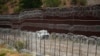 FILE - A vehicle drives along the U.S. side of the US-Mexico border wall in Nogales, Arizona, June 25, 2024.