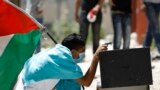 A Palestinian protester uses a toy gun during clashes with Israeli troops over the controversial Israeli barrier in Kfar Aqab near the West Bank city of Ramallah.