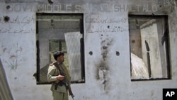 A soldier stands guard at the site of clashes between militants and security forces in Upper Dir, along Pakistan's border with Afghanistan, June 3, 2011