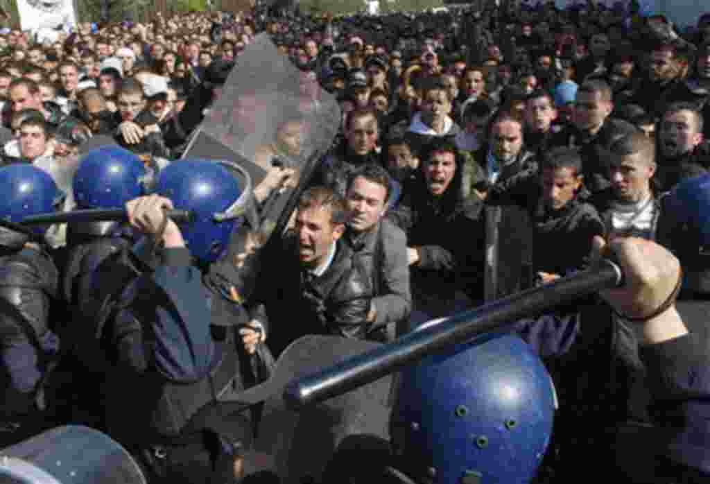 Algerian students scuffle with riot police officers near the Ministry of Higher Education in Algiers, February 21, 2011
