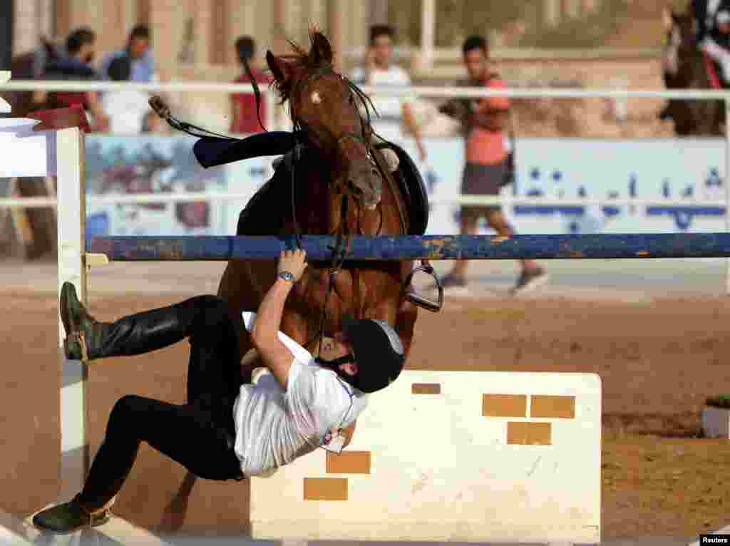 A rider falls from his horse during the Knights of Libya Festival in Benghazi, Libya.