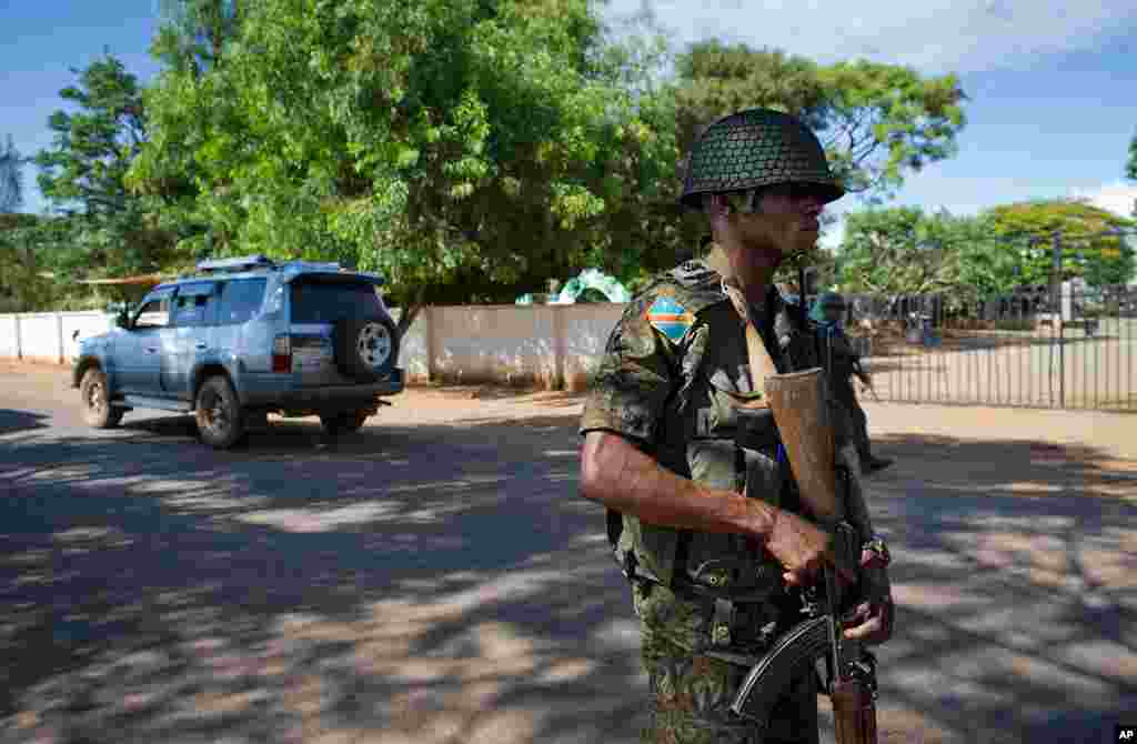 A member of the Congolese national army stands guard outside the "Sapin 2" cemetery in Lubumbashi.  The armed forces have been deployed following several attacks in the city which disrupted voting today, with reports of two policemen killed at a voting ce