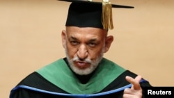 Afghan President Hamid Karzai, wearing an academy gown, delivers a speech as he receives an honorary doctorate at Nippon Sport Science University in Tokyo, July 9, 2012. 