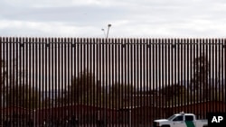 In this April 5, 2019, photo, a U.S. Customs and Border Protection vehicle sits near the a section of the U.S. border wall with Mexico in Calexico, Calif. 