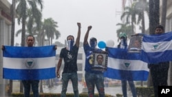 Archivo - Manifestantes sostienen banderas nacionales nicaragüenses y fotos de estudiantes asesinados, durante una marcha antigubernamental denominada "Nada es normal" en honor a Matt Romero, en Managua, Nicaragua, el 21 de septiembre de 2019. 