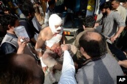 Voluntarios transportan a una víctima de un ataque con bomba hacia un hospital en Peshawar, Pakistán, el 4 de marzo de 2022. Foto: AP.