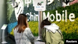 Customers are seen at a China Mobile flagship store displaying smart home experience with 5G network, in Shanghai, China, March 10, 2019.