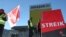 Employees of U.S. online retailer Amazon rally during a strike in front of one of the company's logistics centers, in Graben, Germany, Dec. 16, 2013.