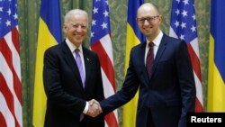 El vicepresidente Joe Biden estrecha la mano al primer ministro ucraniano, Arseniy Yatsenyuk, durante su visita a Kiev. 