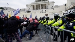 Trump supporters try to break through a police barrier, Jan. 6, 2021, at the Capitol in Washington. 