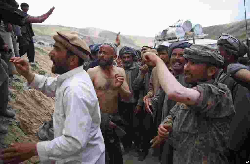 Afghanis show their injuries to local and international journalists after police fired shots into the air to disperse a crowd that had rushed toward a truck carrying aid, near the site of the landslide that buried Abi Barik village in Badakhshan province, northeastern Afghanistan, May 6, 2014.