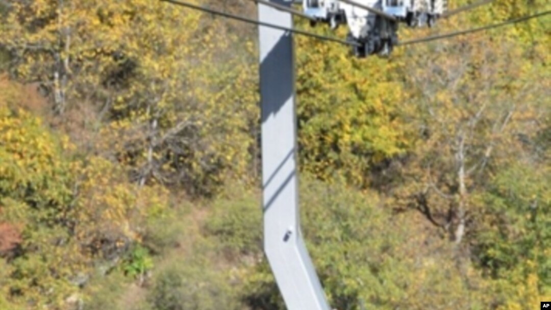 Armenian President Serzh Sarkisian (C) and the head of the Armenian Apostolic Church, Karekin II (L) ride in a cable car at the newly opened cable line near Tatev monastery in Armenia's southern mountains close the border with Iran, 16 Oct 2010