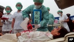 Members of Falun Dafa practitioners simulate organ harvesting in a mock Chinese labor camp in protest against China's suspected abuse and killing of Falun Gong members, Sunday, April 23, 2006, in front of the Presidential Office in Taipei, Taiwan. (AP Photo/Chiang Ying-Ying)