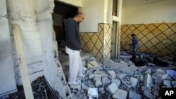 Palestinians inspect the demolished apartment of Abdel Rahman al-Shaludi in east Jerusalem, Israel, Nov. 19, 2014. Israeli authorities demolished the apartment as a punitive measure after al-Shaludi's deadly attack with his car on a Jerusalem train station last month.