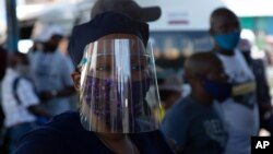 People wear face masks to protect against COVID-19 before boarding a minibus taxi in Johannesburg, Dec. 24,2020.