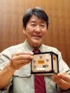 FILE - This file photo taken on May 28, 2024 shows Takao Doi, an astronaut and special professor at Kyoto University, holding the world's first wooden satellite, named LignoSat, during a press conference at the university's campus in Kyoto.