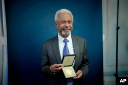 Abdulrazak Gurnah, a Tanzanian-born novelist and emeritus professor who lives in the UK, poses for photographs with his 2021 Nobel Prize for Literature medal, in London, Dec. 6, 2021.