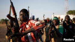 Rebel fighters hold their weapons as they march in a village in the rebel-controlled territory of Upper Nile state, South Sudan, Feb. 9, 2014.