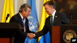 Colombia's President Juan Manuel Santos, right, shakes hands with Ambassador Elbio Rosselli, Permanent Representative of Uruguay to the United Nations, after a joint statement at the presidential palace in Bogota, Colombia, May 4, 2017.