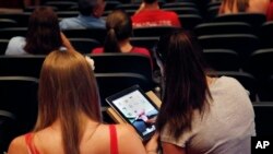 Murid SMA Burlington High School di Burlington, Massachusetts memakai iPad di kelas. Burlington membagikan tablet tersebut untuk lebih dari 1.000 muridnya. Buku pelajaran masih digunakan, tapi mayoritas pelajaran menggunakan tablet. (AP/Elise Amendola)