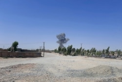 Smoke rises after a car bomb attack at the police headquarters of Lashkar Gah, Helmand province, southwestern Afghanistan, Wednesday, Aug. 11, 2021. (AP Photo/Abdul Khaliq)