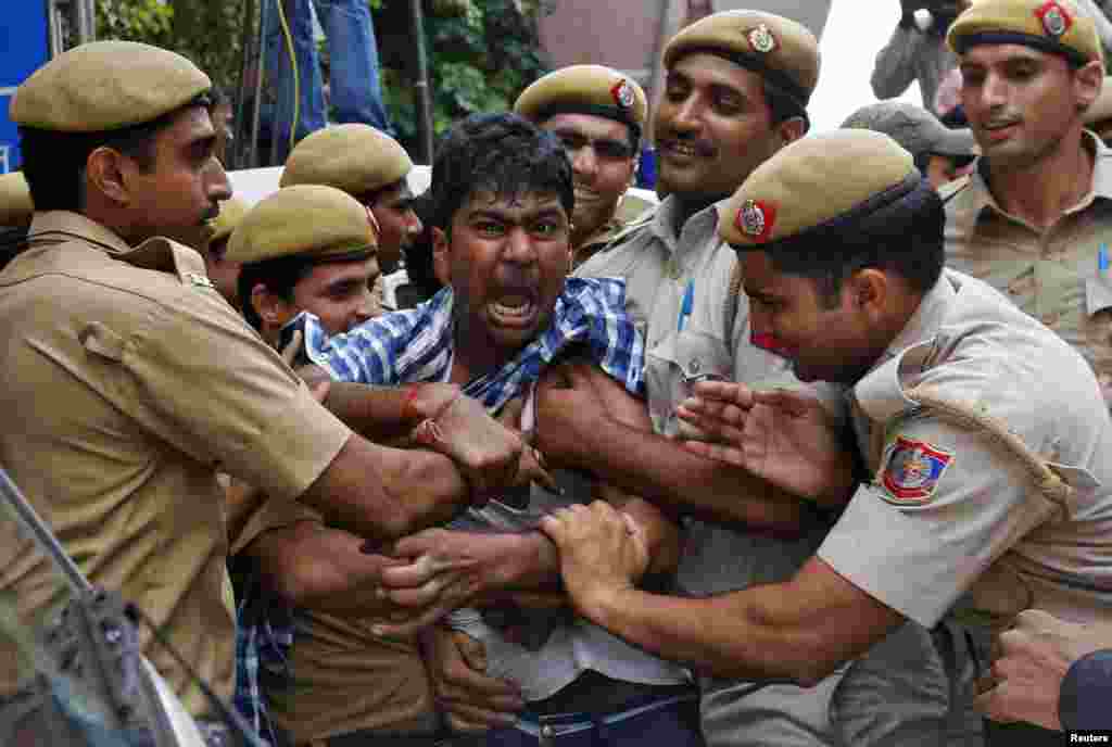 Polisi menahan seorang pendukung Chandrababu Naidu, kepala Partai Telugu Desam (TDP), sebuah partai regional, ketika ia mencoba untuk menghentikan kendaraan yang membawa Naidu ke rumah sakit di New Delhi, India. Lokal media mengatakan Naidu melakukan aksi mogok makan sejak 7 Oktober 2013, memprotes pembentukan negara Telangana.