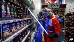 A fan dressed as a Star Wars character shops at a toy store at the midnight in Hong Kong, Sept. 4, 2015, as part of the global event called "Force Friday" to release new toys and other merchandise of the new movie "Star Wars: The Force Awakens." 