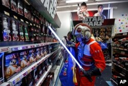 A fan dressed as a Star Wars character shops at a toy store at the midnight in Hong Kong, Sept. 4, 2015, as part of the global event called "Force Friday" to release new toys and other merchandise of the new movie "Star Wars: The Force Awakens."