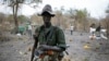 A rebel fighter carries a rocket-propelled grenade (RPG) in a rebel camp in Jonglei State, Feb. 1, 2014.