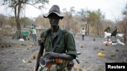 A rebel fighter carries a rocket-propelled grenade (RPG) launcher in a rebel camp in Jonglei State, Feb. 1, 2014.