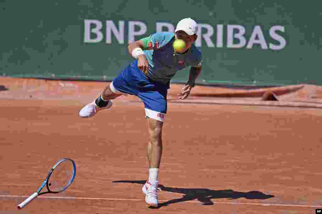 Japan&#39;s Kei Nishikori loses his racket as he serves the ball to Italy&#39;s Alessandro Giannessi during their first round match of the French Open tennis tournament at the Roland Garros stadium in Paris.