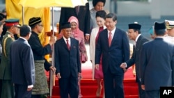 Presiden China Xi Jinping (tengah kanan) dan istrinya Peng Liyuan disambut Raja Malaysia Abdul Halim Mu'adzam Shah (tengah kiri) dan Ratu Haminah Hamidun dengan upacara penyambutan tamu negara di halaman gedung parlemen di Kuala Lumpur, Malaysia (4/10).