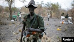 A rebel fighter carries a rocket-propelled grenade (RPG) in a rebel camp in Jonglei State, Feb. 1, 2014.