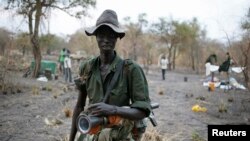 A rebel fighter carries a rocket-propelled grenade (RPG) in a rebel camp in Jonglei State, Feb. 1, 2014.